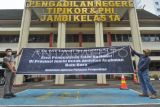 Massa Aliansi Masyarakat Jambi Menggugat membentangkan spanduk orasi saat penyerahan gugatan ke Pengadilan Negeri Jambi, Telanaipura, Jambi, Rabu (8/3/2023). Massa yang terdiri dari gabungan lembaga dan organisasi masyarakat di antaranya, Yayasan Lembaga Konsumen Indonesia (YLKI) Provinsi Jambi secara resmi menyerahkan gugatan kepada sejumlah pihak di antaranya Kementerian ESDM dan Gubernur Jambi terkait kemacetan lalu lintas dan kecelakaan di jalan nasional setempat akibat angkutan batu bara. ANTARA FOTO/Wahdi Septiawan/foc.