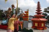 Dua wanita berkebaya berfoto di depan dekorasi  Ogoh-Ogoh dan Pura di depan Balai Kota Surabaya, Jawa Timur, Jumat (10/3/2023). Dekorasi yang dipajang di tempat itu dalam rangka menyambut Hari Raya Nyepi. ANTARA Jatim/Didik Suhartono/zk