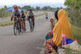 Warga melihat pembalap memacu kecepatan saat mengikuti balap sepeda Tour De Aceh 2023 di Aceh Besar, Aceh, Minggu (12/3/2023). Antara Aceh/Khalis Surry
