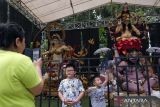 Warga berpose di dekat ogoh-ogoh saat pameran ogoh-ogoh dalam Kesanga Festival di Lapangan Puputan Badung, Denpasar, Bali, Jumat (17/3/2023). Kegiatan yang memamerkan sebanyak 12 ogoh-ogoh berukuran besar dan 33 ogoh-ogoh berukuran mini tersebut digelar untuk menyambut Hari Raya Nyepi Tahun Baru Saka 1945. ANTARA FOTO/Nyoman Hendra Wibowo/wsj.