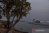 Pengunjung menyaksikan matahari tenggelam di Pantai Sindangkerta, Kabupaten Tasikmalaya, Jawa Barat, Selasa (22/3/2023). Berdasarkan data Balai Besar Konservasi Sumber Daya Alam (BBKSDA) Jawa Barat terdapat lahan seluas 90 hektare di pesisir Pantai Sindangkerta yang merupakan kawasan suaka margasatwa. ANTARA FOTO/Adeng Bustomi/agr
