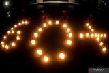 Relawan menyalakan lilin membentuk angka 60 plus saat peringatan Earth Hour di Conrad Bali, Badung, Bali, Sabtu (25/3/2023). Aksi Earth Hour dengan mematikan lampu pada pukul 20.30 hingga 21.30 waktu setempat tersebut dilakukan di berbagai belahan dunia sebagai bentuk kepedulian terhadap kondisi bumi sekaligus sebagai kampanye untuk menghemat pemakaian listrik. ANTARA FOTO/Fikri Yusuf/wsj.