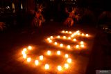 Seniman menari di dekat lilin yang disusun membentuk angka 60 plus saat peringatan Earth Hour di Conrad Bali, Badung, Bali, Sabtu (25/3/2023). Aksi Earth Hour dengan mematikan lampu pada pukul 20.30 hingga 21.30 waktu setempat tersebut dilakukan di berbagai belahan dunia sebagai bentuk kepedulian terhadap kondisi bumi sekaligus sebagai kampanye untuk menghemat pemakaian listrik. ANTARA FOTO/Fikri Yusuf/wsj.