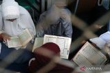 Warga binaan membaca Al Quran saat tadarusan di Blok Wanita Lapas Kelas II Blitar, Jawa Timur, Rabu (29/3/2023). Selain untuk meningkatkan ketakwaan warga binaan, tadarus Al Quran yang dilaksanakan selama bulan ramadhan tersebut juga diharapkan menjadi sarana pembinaan mental terhadap warga binaan agar nantinya bisa membentuk kepribadian yang lebih baik lagi pasca menjalani masa hukuman di lapas dan tidak lagi melakukan tindakan-tindakan yang melanggar hukum. ANTARA Jatim/Irfan Anshori/zk 