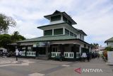 Umat muslim berjalan untuk melaksanakan shalat Zuhur di Masjid Teungku Di Anjong, desa Peulanggahan, Kecamatan Kutaraja, Banda Aceh, Aceh, Kamis (30/3/2023). Masjid Teungku Di Anjong yang kubahnya berbentuk prisma bersegi empat dan bertingkat dua yang dibangun oleh seorang ulama asal Yaman, Sayyid Abu Bakar bin Husin Bafaqih pada abad ke-18  tersebut sempat rusak dan hancur diterjang bencana tsunami 26 Desember 2004 dan kemudian masjid dari kontruksi kayu itu  dibangun kembali menggunakan kontruksi beton dengan tetap mempertahankan arsitektur aslinya. ANTARA FOTO/Ampelsa.