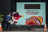 Petugas membersihkan lantai di dekat papan promosi Piala Dunia U-20 Indonesia 2023 di GBK Arena, Jakarta, Kamis (30/3/2023). FIFA resmi mencabut status Indonesia sebagai tuan rumah untuk ajang Piala Dunia U-20 2023. ANTARA FOTO/Aprillio Akbar/tom. 