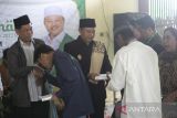 Wakil Gubernur Jawa Barat Uu Ruzhanul Ulum (tengah) memberikan bantuan kepada anak yatim piatu dan santri di Pesantren salafiyah Sirojut Tholibin, Kertasmaya, Indramayu, Jawa Barat, Jumat (31/3/2023). Dalam Kunjungannya Wagub berharap pemerintah daerah bisa memberikan perhatian lebih terhadap pondok pesantren salafiyah dengan memberikan anggaran rutin sehingga dapat menciptakan sumber daya manusia yang unggul. ANTARA FOTO/Dedhez Anggara/agr