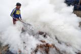 Pekerja membakar batok kelapa saat pembuatan arang di Desa Mekar Jaya, Sungai Gelam, Muarojambi, Jambi, Kamis (30/3/2023). Pemilik usaha menyebutkan permintaan arang batok yang dijual Rp5.200 per kilogram itu saat Ramadhan meningkat dibanding hari biasa yakni dari rata-rata 2,5 ton per minggu menjadi 3,5 ton per minggu. ANTARA FOTO/Wahdi Septiawan/nym.
