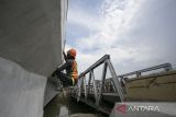 Pekerja menyelesaikan perbaikan jembatan Kalijaga, Cirebon, Jawa Barat, Kamis (6/4/2023). Kementerian Pekerjaan Umum dan Perumahan Rakyat (PUPR) menargetkan perbaikan delapan jembatan di jalur Pantura selesai pada 10 April 2023 agar dapat digunakan saat arus mudik Lebaran. ANTARA FOTO/Dedhez Anggara/agr