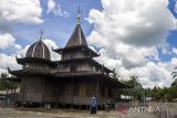 Warga berjalan di halaman Masjid As Suada (Masjid Baangkat) di Desa Wasah Hilir, Kabupaten Hulu Sungai Selatan, Kalimantan Selatan, Jumat (7/4/2023). Masjid yang didirikan pada 1908 Masehi itu memiliki arsitektur berkonsep bangunan rumah tradisional Kalimantan Selatan. ANTARA/ Bayu Pratama S.