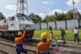 Pekerja menyapa masinis usai perbaikan wesel giometris rel kereta api di perlintasan Kabupaten Ciamis, Jawa Barat, Sabtu (8/4/2023). PT Kereta Api Indonesia (KAI) Daerah Operasi (Daop) 2 Bandung melakukan perawatan dan perbaikan rel untuk memastikan keselamatan serta kenyamanan perjalanan mudik Lebaran serta menambah 82 petugas pemeriksa jalur dan penjaga perlintasan ekstra. ANTARA FOTO/Adeng Bustomi/agr