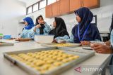 Siswa disabilitas menyelesaikan produksi kue kering di Panti Sosial Rehabilitasi Penyandang Disabilitas, Dinas Sosial Provinsi Jawa Barat di Cimahi, Jawa Barat, Rabu (12/4/2023). Sebanyak 10 orang siswa disabilitas mengikuti pelatihan keterampilan olah tangan dengan memproduksi aneka kue lebaran yang nantinya akan dijual ke masyarakat dan pegawai Dinas Sosial. ANTARA FOTO/Raisan Al Farisi/agr