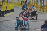 Calon penumpang menaiki becak menuju dermaga kapal feri dalam mudik bareng gratis 2023 di Pelabuhan Jangkar, Situbondo, Jawa Timur, Kamis (13/4/2023). Pemerintah Provinsi Jawa Timur menyediakan layanan mudik bareng gratis menggunakan kapal laut menuju Pulau Raas, Sumenep guna membantu warga pulang ke kampung halaman untuk merayakan Idul Fitri 1444 Hijriah. ANTARA Jatim/Seno/zk