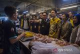 Wakil Menteri Perdagangan (Wamendag) Jerry Sambuaga (ketiga kanan) bersama Gubernur Jawa Barat Ridwan Kamil (tengah) dan Anggota Komisi I DPR RI Nurul Arifin (kedua kanan) berdialog dengan pedagang daging ayam saat meninjau harga ikan saat kegiatan grebek pasar di Pasar Kosambi, Bandung, Jawa Barat, Sabtu (15/4/2023). Kegiatan tersebut untuk memastikan kestabilan harga bahan pokok menjelang hari raya Idul Fitri 1444 hijriah sekaligus mengedukasi pedagang pasar dan pemilik warung untuk bertransformasi secara digital yang sejalan dengan program UMKM Go Digital. ANTARA FOTO/Novrian Arbi/agr