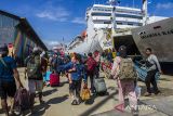 Sejumlah penumpang berjalan menuju Kapal Motor (KM) Dharma Kartika IX di Pelabuhan Trisakti Banjarmasin, Kalimantan Selatan, Senin (17/4/2023). Kantor Kesyahbandaran dan Otoritas Pelabuhan (KSOP) Kelas I Banjarmasin mencatat sejak H-7 hingga H-6 Lebaran pemudik yang menggunakan jasa angkutan laut melalui Pelabuhan Trisakti Banjarmasin mencapai 2.175 orang dan terus bertambah. ANTARA/Bayu Pratama S.