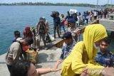 Pemudik berjalan di dermaga sebelum menaiki Kapal Latih Bung Tomo di Pelabuhan Jangkar, Situbondo, Jawa Timur, Minggu (16/4/2023). Kantor Kesyahbandaran dan Otoritas Pelabuhan (KSOP) Kelas IV Panarukan Situbondo bekerjasama dengan Politeknik Pelayaran Surabaya menyediakan Kapal Latih Bung Tomo memberikan layanan mudik gratisÂ ke Pulau Sapudi, Sumenep untuk mengurangi penumpukan pemudik di masa mudik Lebaran 2023. ANTARA Jatim/Seno/Zk