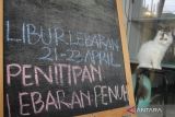 Seekor kucing milik warga duduk di samping papan pengumuman yang dipasang di Kenes Cat Hotel, Malang, Jawa Timur, Selasa (17/4/2023). Menurut pengusaha menjelang mudik lebaran permintaan layanan jasa hotel kucing yang terdiri dari jasa penitipan, jasa perawatan dan jasa pengasuhan kucing yang dikelolanya mengalami peningkatan dari 30 ekor menjadi 80 ekor per hari dengan biaya Rp35.000 hingga 100 ribu rupiah per hari tergantung jenis layanan.  ANTARA Jatim/Ari Bowo Sucipto/zk 