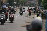 Sejumlah warga menunggu pengendara memberi sedekah dengan melempar uang di Jembatan Sewo, Jalur Pantura Sukra Indramayu, Jawa Barat, Senin (17/4/2023). Aksi mengambil uang sedekah menggunakan sapu tersebut dapat membahayakan keselamatan pengguna jalan terutama saat arus mudik. ANTARA FOTO/Dedhez Anggara/aww.
