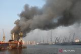  Asap tebal membumbung dari KM Anugerah Mandiri 8 yang terbakar di atas dok apung PT DOK dan Perkapalan Surabaya, Pelabuhan Tanjung Perak, Surabaya, Jawa Timur, Rabu (19/4/2023). Sejumlah unit kendaraan pemadam kebakaran dan kapal tunda (tug boat) dikerahkan untuk memadamkan kebakaran kapal kargo yang sedang dalam perbaikan tersebut. ANTARA Jatim/Didik Suhartono/zk 