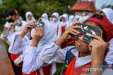 Siswa Sekolah Dasar mengamati gerhana matahari sebagian menggunakan kacamata matahari di Observatorium Bosscha, Lembang, Kabupaten Bandung Barat, Jawa Barat, Kamis (20/4/2023). Observatorium Bosscha menggelar pengamatan gerhana matahari sebagian bagi pelajar SD dan SMP secara gratis guna mengedukasi pelajar mengenai fenomena astronomi yang terjadi setiap seratus tahun sekali. ANTARA FOTO/Raisan Al Farisi/agr