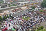 Foto udara umat Islam melaksanakan Shalat Idul Fitri 1444 Hijriyah di halaman Stasiun Purwakarta, Nagritengah Purwakarta, Jawa Barat, Jumat (21/4/2023). Pimpinan Pusat Muhammadiyah menetapkan 1 Syawal 1444H jatuh pada hari Jumat 21 April 2023, lebih awal 1 hari dari ketetapan pemerintah. ANTARA FOTO/M Risyal Hidayat/rwa.
