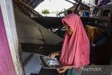 Warga melihat foto dirinya yang di ambil dari rumah yang rusak akibat ditabrak kapal tongkang di Desa Keladan, Kabupaten Tapin, Kalimantan Selatan, Minggu (23/4/2023). Dua kapal tongkang pengangkut batu bara milik perusahaan PT Rimau Bahtera Shiping dan PT Batu Gunung Mulia Energi menghancurkan sebanyak 35 rumah serta puluhan alat transportasi air milik warga di permukiman padat penduduk, penyebab diduga akibat angin deras pada Sabtu (22/4/2023) sore. ANTARA/Bayu Pratama S.