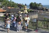 Wisatawan berjalan di kawasan objek wisata Tanah Lot, Tabanan, Bali, Minggu (23/4/2023). Pengelola Daya Tarik Wisata (DTW) Tanah Lot mencatat jumlah kunjungan wisatawan saat hari libur Idul Fitri 1444 H pada Sabtu (22/4) sebanyak 9.202 orang, angka tersebut meningkat dibandingkan jumlah kunjungan pada hari-hari biasa yang rata-rata 2.000 orang. ANTARA FOTO/Nyoman Hendra Wibowo/wsj.