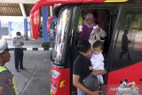 Penumpang turun dari bus Antar Kota Antar Provinsi (AKAP) saat arus milir Lebaran 1444 H di Terminal Mengwi, Badung, Bali, Selasa (25/4/2023). Koordinator Satuan Pelayanan Terminal Tipe A Mengwi menyebutkan pada Senin (24/4) pergerakan penumpang yang datang dari Pulau Jawa di terminal tersebut mencapai 598 orang dari 26 unit bus dan diperkirakan puncak arus milir terjadi pada Senin (1/5) mendatang. ANTARA FOTO/Nyoman Hendra Wibowo/wsj.
