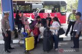 Petugas gabungan mengawasi kedatangan penumpang saat arus milir Lebaran 1444 H di Terminal Mengwi, Badung, Bali, Selasa (25/4/2023). Koordinator Satuan Pelayanan Terminal Tipe A Mengwi menyebutkan pada Senin (24/4) pergerakan penumpang yang datang dari Pulau Jawa di terminal tersebut mencapai 598 orang dari 26 unit bus dan diperkirakan puncak arus milir terjadi pada Senin (1/5) mendatang. ANTARA FOTO/Nyoman Hendra Wibowo/wsj.
