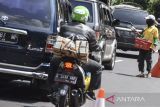 Pedagang asongan menawarkan barang daganganya kepada pemudik saat terjadi antrean di Lingkar Gentong, Kabupaten Tasikmalaya, Jawa Barat, Selasa (25/4/2023). Warga setempat memanfaatkan kemacetan pada musim arus balik Lebaran untuk berjualan makanan ringan dan minuman segar, dengan omset yang didapat mencapai Rp200 ribu hingga Rp300 ribu per hari. ANTARA FOTO/Adeng Bustomi/agr