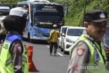 Pedagang asongan menawarkan barang daganganya kepada pemudik saat terjadi antrean di Lingkar Gentong, Kabupaten Tasikmalaya, Jawa Barat, Selasa (25/4/2023). Warga setempat memanfaatkan kemacetan pada musim arus balik Lebaran untuk berjualan makanan ringan dan minuman segar, dengan omset yang didapat mencapai Rp200 ribu hingga Rp300 ribu per hari. ANTARA FOTO/Adeng Bustomi/agr