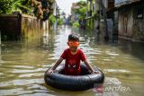 Seorang anak bermain saat banjir melanda Kampung Bojongasih, Dayeuhkolot, Kabupaten Bandung, Jawa Barat, Kamis (27/4/2023). Banjir setinggi 50 sentimeter hingga satu meter sejak Rabu (26/4/2023) malam akibat luapan Sungai Citarum tersebut disebabkan intensitas hujan yang tinggi di kawasan Bandung Raya. ANTARA FOTO/Raisan Al Farisi/agr