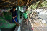 Warga membersihkan lumpur usai terjadi banjir bandang di Sembahe, Deli Serdang, Sumatera Utara, Senin (1/5/2023). Berdasarkan data Badan Penanggulangan Bencana Daerah (BPBD) Provinsi Sumatera Utara, banjir bandang yang terjadi pada Minggu 30 April 2023 tersebut mengakibatkan sejumlah fasilitas wisata alam pemandian sungai rusak, dua unit rumah rusak dan satu mobil mini bus terseret arus. ANTARA FOTO/Fransisco Carolio