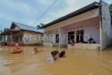 Warga menerobos jalan yang terendam banjir di Suka Karya, Kota Baru, Jambi, Senin (1/5/2023). Banjir yang merendam seratusan rumah di satu kecamatan itu terjadi akibat hujan deras sejak Senin (1/5/2023) dini hari. ANTARA FOTO/Wahdi Septiawan/pras.