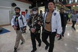 Petugas Dittipidsiber Bareskrim Polri membawa peneliti dari Badan Riset dan Inovasi Nasional (BRIN) Andi Pangerang Hasanuddin (tengah) setibanya di Terminal 2 Bandara Soekarno, Hatta, Tangerang, Banten, Minggu (30/4/2023). Andi Pangerang Hasanuddin ditangkap terkait komentarnya yang bernada ancaman terhadap warga Muhammadiyah beberapa waktu lalu di media sosial. ANTARA FOTO/Muhammad Iqbal/nz