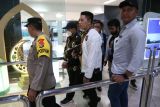 Petugas Dittipidsiber Bareskrim Polri membawa peneliti dari Badan Riset dan Inovasi Nasional (BRIN) Andi Pangerang Hasanuddin (tengah) setibanya di Terminal 2 Bandara Soekarno, Hatta, Tangerang, Banten, Minggu (30/4/2023). Andi Pangerang Hasanuddin ditangkap terkait komentarnya yang bernada ancaman terhadap warga Muhammadiyah beberapa waktu lalu di media sosial. ANTARA FOTO/Muhammad Iqbal/nz