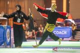 Pesilat putri Indonesia Puspa Arum Sari mengibarkan bendera Merah Putih seusai final pencak silat nomor seni tunggal putri saat SEA Games 2023 di Chroy Changvar International Convention & Exhibition Center, Phnom Penh, Kamboja, Minggu (7/5/2023). Puspa Arum Sari meraih medali emas dalam nomor pertandingan tersebut dengan perolehan skor 9.970. ANTARA FOTO/M Agung Rajasa/nym.