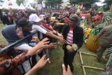 Warga membagikan buah nanas kepada pengunjung saat Festival Nanas di kawasan penghasil nanas lereng gunung Kelud Desa Sugihwaras, Kediri, Jawa Timur, Minggu (7/5/2023). Kegiatan dengan membagiakan ribuan buah nanas secara gratis tersebut sebagai upaya mempromosikan nanas unggulan hasil panen petani lereng gunung Kelud yang tersebar di 13 desa. Antara Jatim/Prasetia Fauzani/zk.