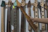 Perajin menggantung salah satu bagian gitar kustom buatannya di rumah produksi Almer Custom Guitar, Oro-oro dowo, Malang, Jawa Timur, Sabtu (6/5/2023). Produksi gitar kustom bergaya natural yang dijual seharga Rp8 juta hingga Rp17 juta per unit tergantung model dan motif tersebut dipasarkan ke sejumlah kota di tanah air hingga diekspor ke Amerika Serikat dan Vietnam. Antara Jatim/Ari Bowo Sucipto/zk.