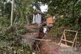 Warga mencari barang yang bisa diselamatkan dalam kondisi rumahnya yang roboh di Desa Saguling, Kabupaten Ciamis, Jawa Barat, Senin (8/5/2023). Bencana pergerakan tanah seluas dua hektare yang terjadi sejak Jumat (5/5/2023) pagi itu mengakibatkan satu rumah roboh, lima rumah retak dan warga terpaksa mengungsi ditempat yang aman. ANTARA FOTO/Adeng Bustomi/agr