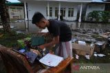 Seorang santri mengemas buku-buku yang diselamatkan dari bangunan laboratorium yang terkena ledakan semburan lumpur panas di Pondok Pesantren Nurul Alamiyyah di Wajok Hilir, Kecamatan Jungkat, Kabupaten Mempawah, Kalimantan Barat, Senin (8/5/2023). Semburan lumpur panas tersebut terjadi setelah pihak pondok pesantren melakukan pengeboran tanah sedalam 40 meter untuk mendapatkan sumber air bersih, lalu kemudian terjadi ledakan yang menghantam bangunan laboratorium. ANTARA FOTO/Jessica Helena Wuysang