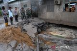 Sejumlah aparat, aparatur pemerintah dan warga berdiri di lokasi semburan lumpur panas di Pondok Pesantren Nurul Alamiyyah di Wajok Hilir, Kecamatan Jungkat, Kabupaten Mempawah, Kalimantan Barat, Senin (8/5/2023). Semburan lumpur panas tersebut terjadi setelah pihak pondok pesantren melakukan pengeboran tanah sedalam 40 meter untuk mendapatkan sumber air bersih, lalu kemudian terjadi ledakan yang menghantam bangunan laboratorium. ANTARA FOTO/Jessica Helena Wuysang