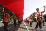 Sejumlah pemuda dan pemudi membawa bendera sepanjang 77 meter saat Kirab Kebangsaan di Kediri, Jawa Timur, Jumat (12/5/2023). Kirab yang diikuti oleh sedikitnya 5.200 pemuda dan pemudi dari sejumlah organisasi kepemudaan dan pelajar tersebut guna memperingati Hut ke-1219 Kediri sekaligus sebagai upaya memupuk semangat persatuan menjelang Pemilu 2024. ANTARA Jatim/Prasetia Fauzani/zk