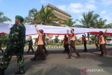 Sejumlah pemuda membawa bendera sepanjang 77 meter dengan latar belakang Monumen Simpang Lima Gumul saat Kirab Kebangsaan di Kediri, Jawa Timur, Jumat (12/5/2023). Kirab yang diikuti oleh sedikitnya 5.200 pemuda dan pemudi dari sejumlah organisasi kepemudaan dan pelajar tersebut guna memperingati Hut ke-1219 Kediri sekaligus sebagai upaya memupuk semangat persatuan menjelang Pemilu 2024. ANTARA Jatim/Prasetia Fauzani/zk