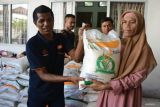 Penyaluran Pangan Beras Tahap Dua. Petugas menyalurkan bantuan pangan beras kepada keluarga penerima manfaat (KPM) di kantor PT Pos  Indonersia (Persero) Cabang Banda Aceh, Aceh, Jumat (12/5/2023). PT POS Indonesia (Persero ) menargetkan distribusi bantuan pangan beras tahap ke-dua kepada 21,3 juta keluarga penerima manfaat (KPM) di  38 provinsi selesai pada minggu ke dua Mei 2023. ANTARA FOTO/Ampelsa