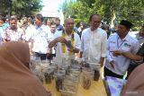 Menteri Koperasi dan Usaha Kecil dan Menengah (Menkop UKM) Teten Masduki (ketiga kanan) melihat hasil produk UMKM masyarakat pesisir saat menghadiri musyawarah kerja nasional (Mukernas) IV Kesatuan Nelayan Tradisional Indonesia (KNTI) di Lhoknga, Aceh Besar, Aceh, Minggu (14/5/2023). Mukernas IV KNTI yang diikuti seluruh pengurus DPP, DPW dan DPD KNTI seluruh Indonesia tersebut bertema 