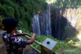 Pengunjung menikmati pemandangan air terjun Coban Sewu di Sidomulyo, Pronojiwo, Lumajang, Jawa Timur, Sabtu (13/5/2023). Air terjun setinggi 120 meter menyerupai tirai yang berhulu di Gunung Semeru itu merupakan salah satu wisata alam yang sering dikunjungi wisatawan. ANTARA Jatim/Budi Candra Setya/zk