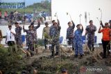 Komandan Puspenerbal Laksamana Muda TNI Imam Musani (ketiga kiri) Komandan Lanudal Juanda Kolonel Laut (P) Heru Prasetyo (kedua kiri) bersama personil TNI, Polri dan Forkopimda membawa bibit mangrove untuk ditanam di kawasan Muara Desa Gisik Cemandi, Sedati, Jawa Timur, Senin (15/5/2023). Penanaman pohon mangrove serentak tersebut bertujuan untuk mendukung program pemerintah dalam pelestarian dan peremajaan kembali hutan mangrove di wilayah pesisir dan pulau-pulau, serta mewujudkan pemberdayaan wilayah pertahanan laut dalam rangka mendukung tugas pokok TNI. ANTARA Jatim/Umarul Faruq/zk 