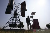 Perangkat desa menunjukkan instalasi pembangkit listrik tenaga angin di desa Sindang, Indramayu, Jawa Barat, Rabu (17/5/2023). Pemdes Sindang menggunakan dana desa untuk membuat inovasi pembangkit listrik tenaga angin yang terintegrasi dengan pembangkit listrik tenaga surya dan bisa menghasilkan listrik berkapasitas 4.000 watt untuk memenuhi kebutuhan listrik di wilayah yang belum terjangkau aliran listrik dari PLN. ANTARA FOTO/Dedhez Anggara/agr