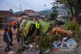Polisi dibantu warga mengevakuasi truk bermuatan air minum yang mengalami kecelakaan di Nagreg, Kabupaten Bandung, Jawa Barat, Kamis (18/5/2023). Kepolisian menyatakan truk bermuatan air minum tersebut mengalami kecelakaan akibat rem blong sehingga menutup akses jalan nasional menuju Tasikmalaya dan tidak ada korban jiwa dalam kecelakaan tersebut. ANTARA FOTO/Raisan Al Farisi/agr